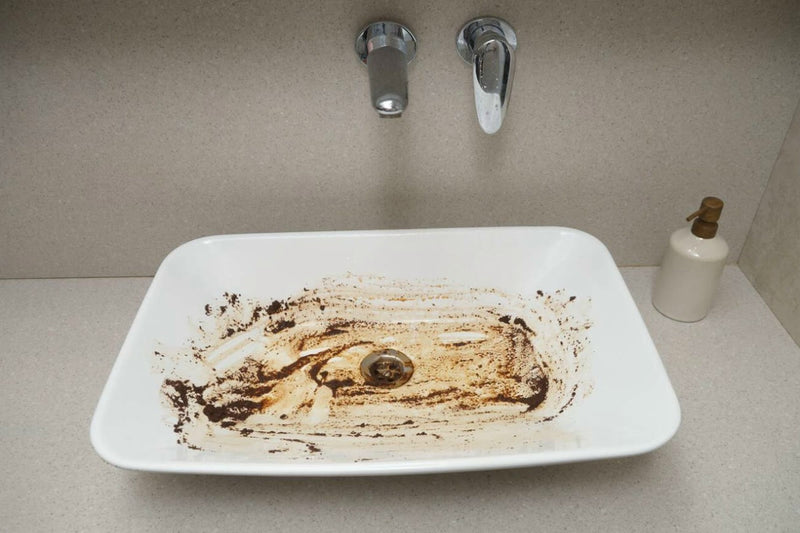 Waschbecken mit eingetrockneten Kaffee- und Schmutzrändern vor der Reinigung